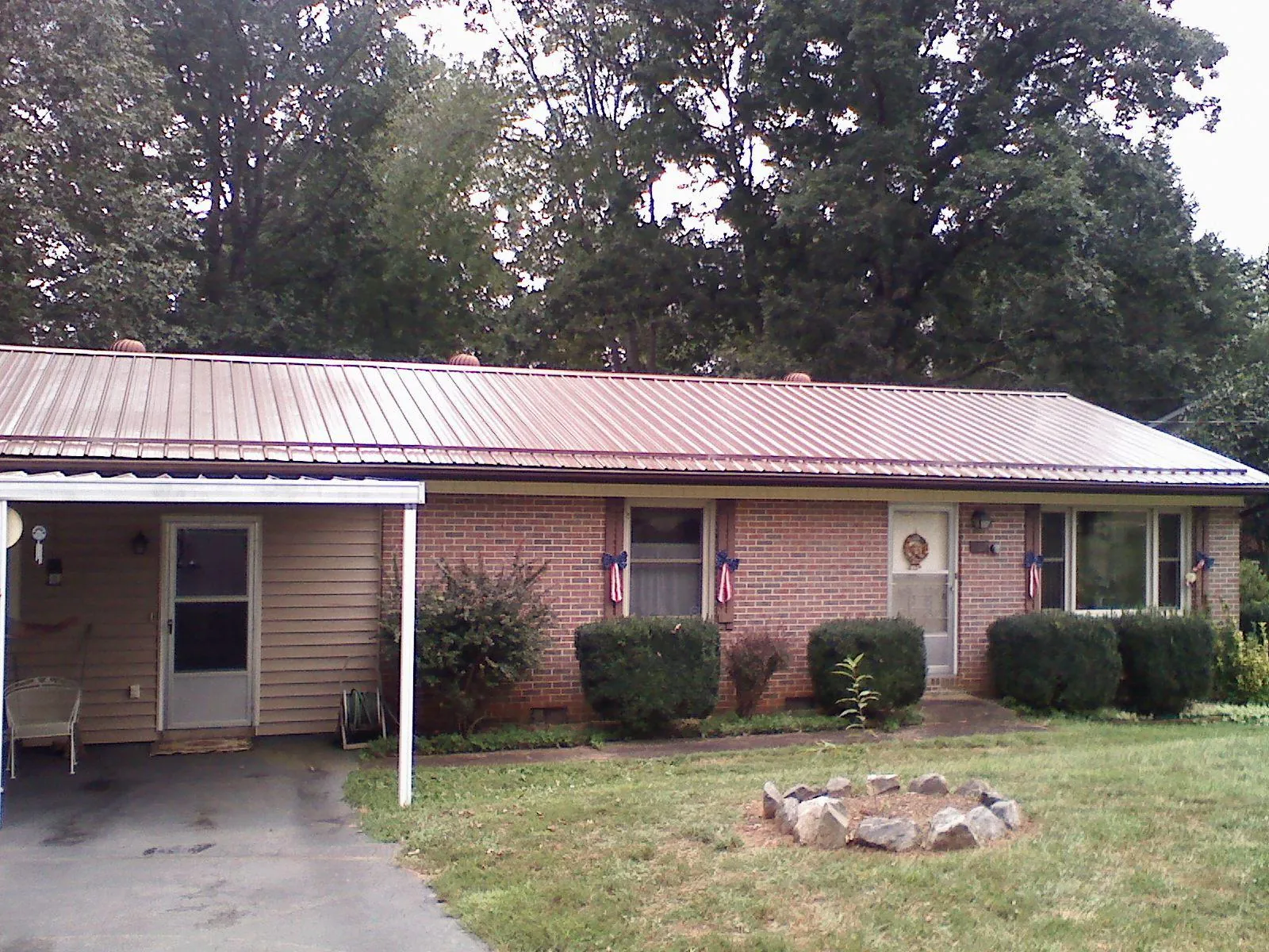 Bronze metal roof and carport on a brick ranch home — Roof Repair work by our crew in New Cumberland